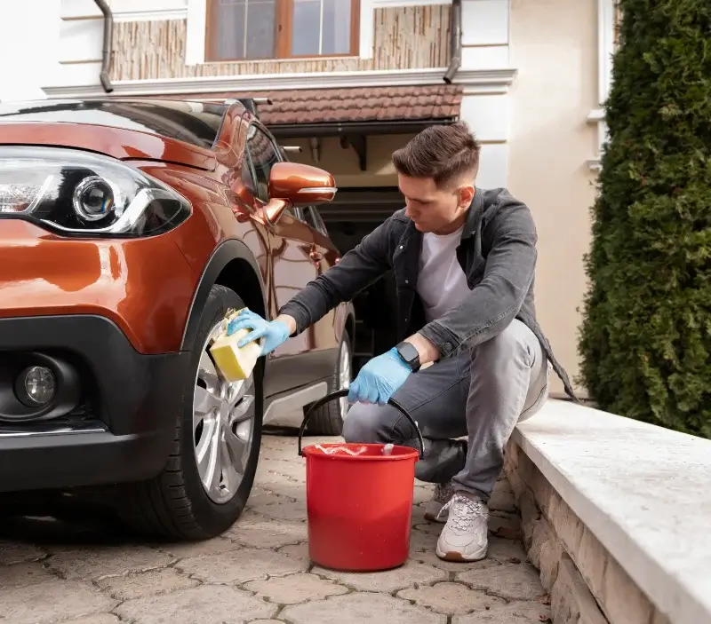 Lavage auto à domicile Heugueville-sur-Sienne : professionnel intervenant sur un véhicule